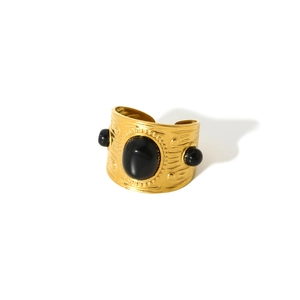 Macro detail of vintage gold-plated ring with black gemstones and relief texture
