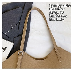 Close-up of litchi grain leather strap with silver metal buckle on a khaki tote bag