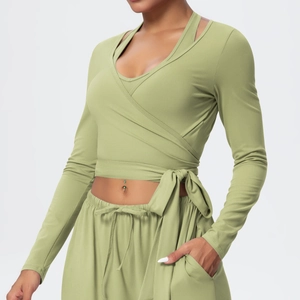 Detail of olive green yoga set featuring a V-neck wrap top with side tie and drawstring pants