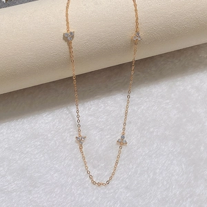 Detailed close-up of a delicate gold choker featuring three-petal zircon floral accents