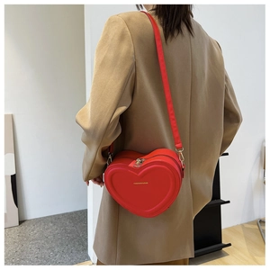 Dettaglio della borsa a tracolla rossa a forma di cuore che mostra le dimensioni e la vestibilità