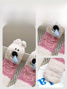 Détail de chaussettes en polaire corail rose avec nez 3D bleu et broderie d'ours