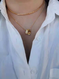 Double-layered gold necklace with minimalist thin chain and irregular round pendant on model