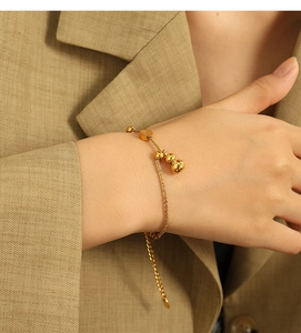 Detailed close-up of a gold stainless steel gourd charm bracelet on a female wrist