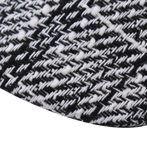 Close-up of black and white checkered tweed fabric texture for newsboy octagonal hats