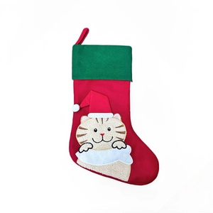 Détail de la botte de Noël en lin rouge avec broderie de chat et revers vert festif