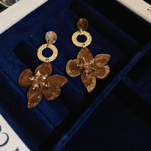 Detailed close-up of vintage resin flower earrings in a velvet jewelry box