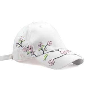 Detail of pink cherry blossom embroidery on white cotton baseball cap with twill texture