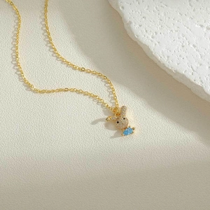 Close-up of golden bunny necklace with blue water-drop zircon and crystal accents