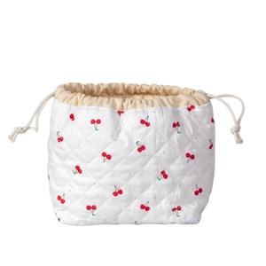 Quilted white drawstring makeup bag featuring red cherry patterns in a shell-shaped design