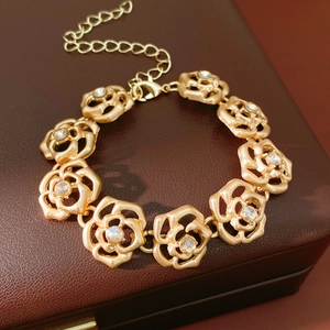 Detailed close-up of golden hollow rose flower bracelet with sparkling crystals