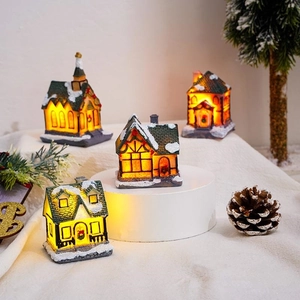 Set of 4 glowing resin Christmas village houses with warm LED lights and snow decor