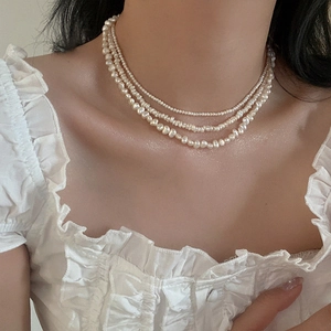 Close-up of triple-layered baroque freshwater pearl necklace on a female model neck