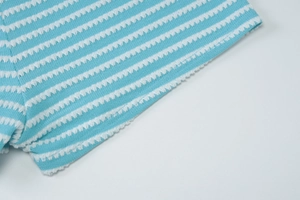 Close-up of light blue and white striped knit fabric with seersucker texture detailing