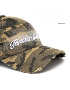 Detailed macro of camouflage baseball cap showing frayed edges and 3D letter embroidery