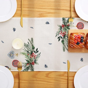 Christmas table runner with festive plant prints and berries on a rustic wooden table