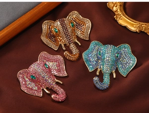 Detailed macro view of three elephant brooches with pink, blue and brown crystals