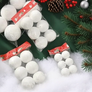 Multiple packs of white foam Christmas snowballs with hangers on festive snow background