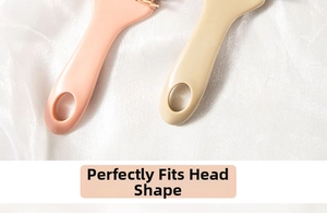 Detail view of pink and beige hairbrush handles featuring oval hanging holes on silk fabric