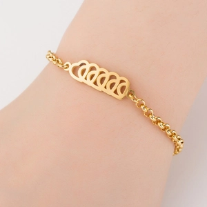 Detail of a gold titanium steel bracelet featuring hollow heart charms on a female wrist