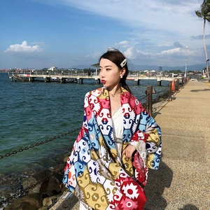Close-up of ethnic paisley beach shawl flowing in the sea breeze on a sunny day