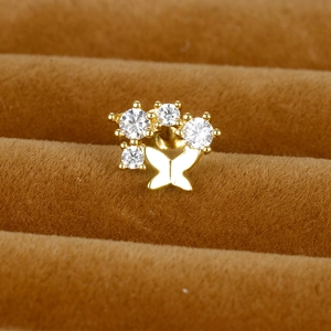 Boucle d'oreille papillon en acier doré avec zircons brillants sur support à bijoux
