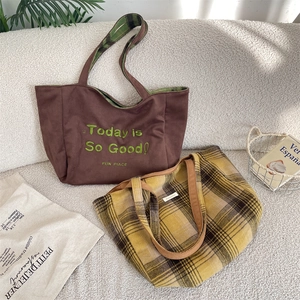 Detail of a reversible oversized tote bag in brown suede and vintage plaid fabric