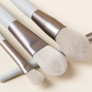 Detailed close-up of soft synthetic bristles and matte champagne gold ferrules on brushes