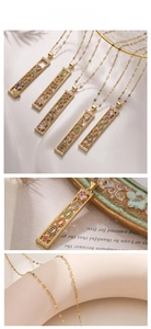 Macro shot of gold rectangle pendants with colorful zircon LOVE and LUCKY lettering