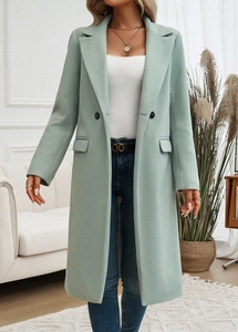 Detail of mint green wool coat featuring notched lapel and double-breasted buttons