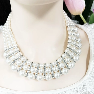 Macro detail of three-layer pearl necklace with silver crystal spacers on neck