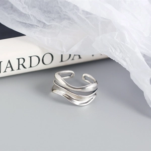 Detailed view of silver double-layered wavy ring on minimalist aesthetic background