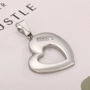 Close-up of heart-shaped stainless steel pendant with three inlaid diamond accents