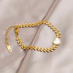 Detail of 18K gold-plated wheat-patterned bracelet with white heart on pink silk cloth