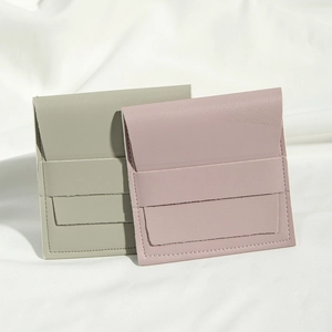 Detail of PU leather envelope jewelry pouches in dusty pink and sage green colors