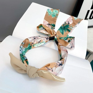 Detail of floral headband with beige bow and vintage flower pattern on white book