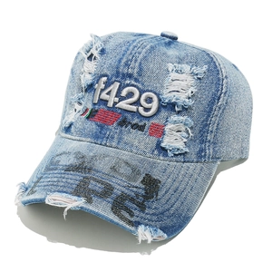 Detail of distressed denim baseball cap with 1429 embroidery and worn ripped texture