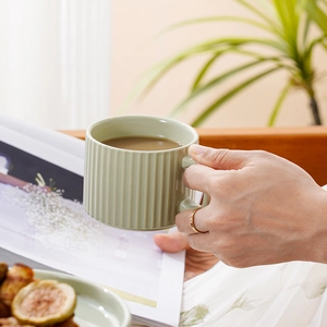 Minimalist light green ceramic coffee mug with vertical stripes for elegant afternoon tea