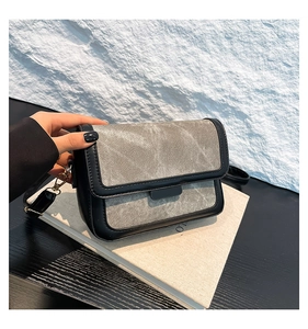 Detail of the black leather and grey fabric texture on this stylish crossbody flap bag