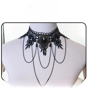 Detail of gothic black lace choker with faux gemstone and hanging delicate chains