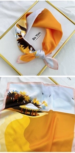 Detail of square silk scarf featuring a warm orange tropical palm tree island print