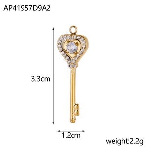 Macro view of a 3.3cm gold heart key pendant with white rhinestones and a central stone