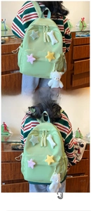 Green canvas backpack for students featuring colorful plush stars and a white bear charm
