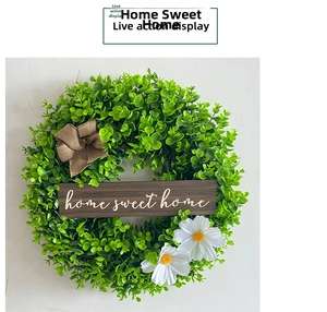 Detailed view of green artificial wreath featuring home sweet home sign and burlap bow