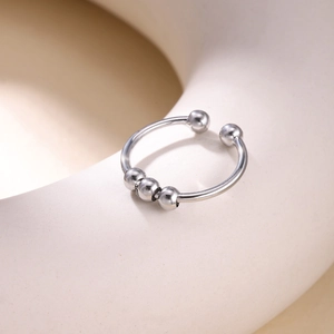 Macro detail of silver anti-anxiety ring with sliding beads and open adjustable band