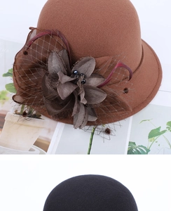 Detail of elegant brown wool felt cloche hat with floral mesh and feather decoration