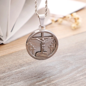 Macro shot of silver stainless steel Jesus cross pendant with engraved Lord Prayer