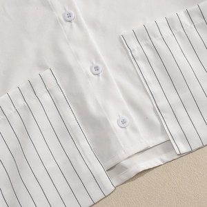 Détail du bouton blanc et du tissu à rayures noires sur la chemise pour femmes