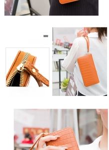 Detail view of orange crocodile texture lady wallet with golden zipper and wristlet strap