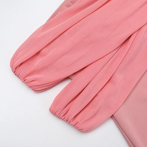 Detail of pink chiffon sleeves featuring elegant pleated elastic cuffs and sheer mesh fabric